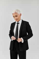 A fashionable woman with short hair adjusts her tie with poise.