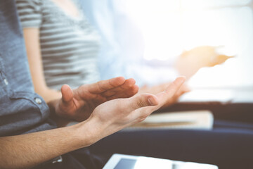 Business people clapping at meeting or conference, close-up of hands. Group of unknown businessmen...