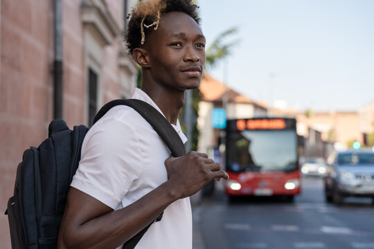 Young student waiting for bus in city center