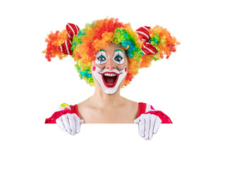 Funny female clown peeking out from behind sign blank template mock up for advertising, posters, greetings, invitations. Entertainer as Joker in a suit and wig, with clown whiteface makeup. © TSViPhoto
