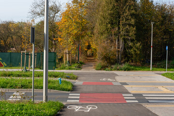 Obraz premium Bicycle and pedestrian path surrounded by autumn trees and greenery. Concept of active recreation, cycling and nature. High quality photo