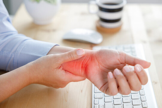 Young woman with wrist pain while using computer