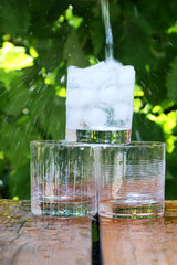Eau qui coule dans un verre avec des glaçons