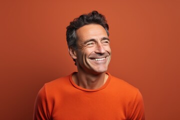 Obraz premium Portrait of a cheerful man in his 40s showing off a thermal merino wool top in solid color backdrop
