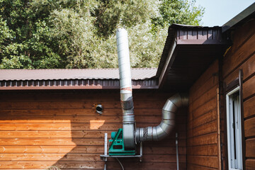 A sturdy metal pipe is securely attached to the side of a wooden house, contributing to the overall...