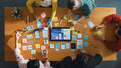 Top view of software developer team looking Ux Ui design for mobile phone interface from tablet...