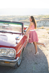 beautiful girl in a retro dress at sunrise happy posing on the background of the mountain landscape...