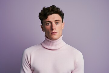 Obraz premium Portrait of a merry man in his 20s wearing a classic turtleneck sweater isolated on solid pastel color wall