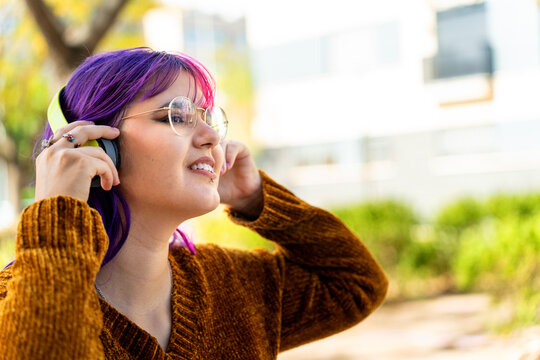 Body positive autistic girl with pink hair enjoying music