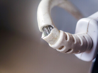 Close-up of a damaged electrical cable showing exposed wires and frayed insulation. A visual representation of electrical hazards and safety concerns.