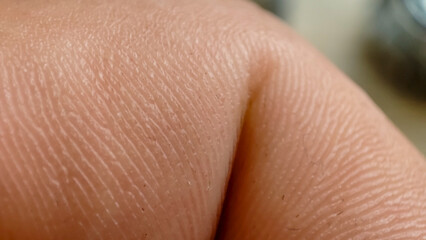 Fototapeta premium Close-up of a human finger highlighting skin texture and details. Aesthetic and tactile representation of human anatomy.