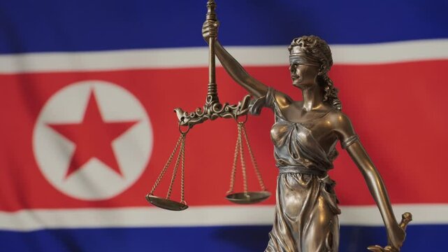 Lady Justice statue with North Korean flag as background. North Korea Law and justice concept. Legal system.