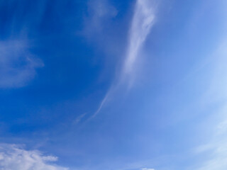 Obraz premium A bright blue sky with soft white clouds, creating a serene atmosphere. Perfect for backgrounds and creative projects.