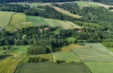 Aerial view of lush green fields and forests, showcasing the beauty of rural landscapes.