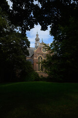Church appearing through branches and leaves of trees. 