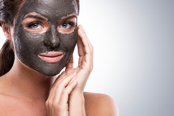 Woman Applying Black Mud Mask for Deep Facial Cleansing