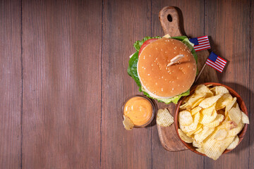 Tasty cheeseburger, chips and sauce with patriotic american flag