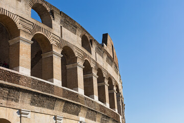 Fototapeta premium The legendary Coliseum of Rome, Italy. Pula Arena, ancient Roman Amphitheatre old stone walls of aged building. Classic colosseum. Travel and history concept. Italian architecture.