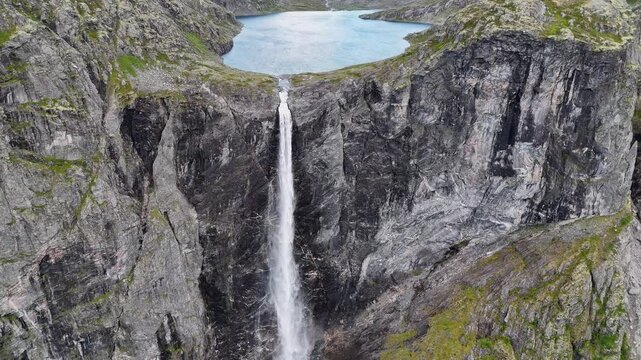 Epic waterfall in clouds zoom out drone shot, double waterfall of Mardalsfossen in Norway in 4K.
