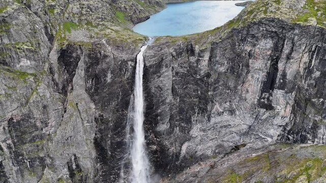 Epic waterfall in clouds zoom out drone shot, double waterfall of Mardalsfossen in Norway in 4K.