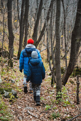 Two young children are happily walking together through a beautiful and lush forest, surrounded by vibrant trees and a serene natural landscape that captures their playful spirits
