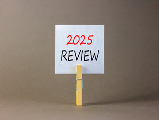 Planning 2025 review new year symbol. Concept words 2025 Review on beautiful white paper on wooden clothespin. Beautiful grey background. Business 2025 review new year concept. Copy space.
