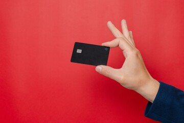 Blank credit card with online service for mockup in businessman's hand on pink background. Modern way of banking and buying. Business, earning. Space for text