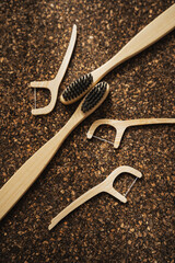 Obraz premium Bamboo Toothbrushes and Floss Picks on Cork Surface