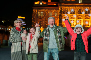 Caucasian senior couple with their young grandson and granddaughter enjoy a festive evening...