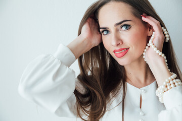 Fototapeta premium Portrait of a beautiful woman in a white summer dress smiling