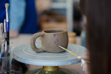 Handcrafted Clay Mug Being Painted by Artisan in a Studio Environment
