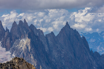 Snow covered mountains and rocky peaks of the Alps from the sky way between Chamonix and Courmayeur in Italy and France Alps. Dent du Gigante rocky towering peak and glacier at the bottom of Montblanc