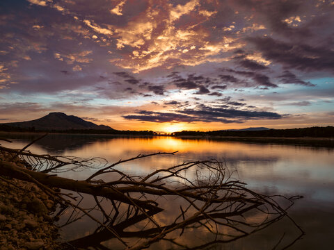 Landscape of a lake with the reflection of the mountains and clouds at autumn sunset in Granada (Spain)