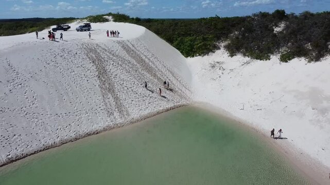 A drone reveals the vast white dunes of Len&ccedil;&oacute;is Maranhenses, with shimmering lagoons nestled between the rolling sands. The sweeping aerial view captures the stunning contrast of the endless desert.