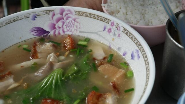 Crispy pork and pork stomach in soup with rice