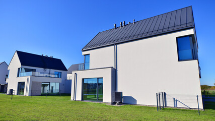 Obraz premium New elegant modern single family house. Terraced family homes in newly developed housing estate. Facade of a modern house with white walls. Real estate concept, european style.