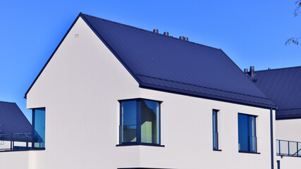 Obraz premium New elegant modern single family house. Terraced family homes in newly developed housing estate. Facade of a modern house with white walls. Real estate concept, european style. 