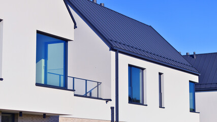 New elegant modern single family house. Terraced family homes in newly developed housing estate. Facade of a modern house with white walls. Real estate concept, european style.  