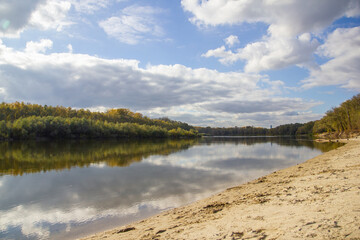 landscape sandy beach on the bank of the river Desna in Chernigov, dense forest behind the river