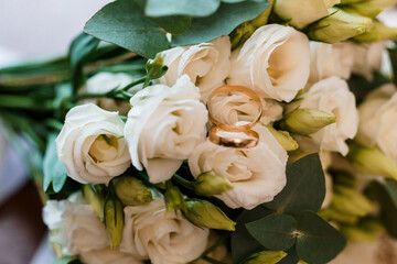 Elegant Wedding Bouquet with Gold Rings Among White Roses
