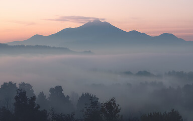 Fototapeta premium Misty mountain landscape with pink and blue hues perfect for nature and tranquility themes 