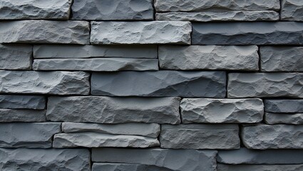 Stone veneer wall with stacked slate stones in shades of gray and black natural layered look