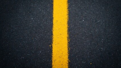 Fototapeta premium Vibrant yellow line on freshly painted black asphalt road