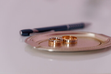 Elegant Wedding Rings on a Decorative Silver Tray with a Pen