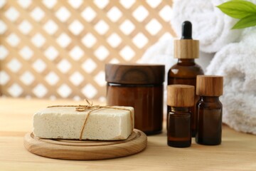 Composition with cosmetic products for spa treatment on wooden table, closeup
