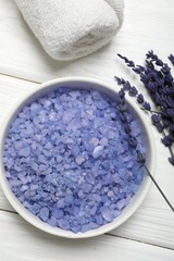 Spa composition with sea salt, towel and lavender flowers on white wooden table, flat lay