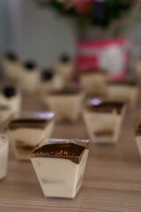 Delicious Mini Dessert Cups with Chocolate Topping on a Rustic Wooden Table
