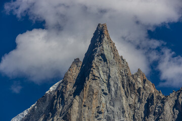 The Petit Dru mountain summit displays rugged peaks and rocky formations against clear sky. Rocky...