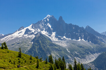 The Petit Dru mountain summit displays rugged peaks and rocky formations against clear sky. Rocky...