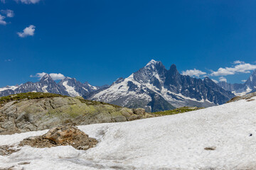 The Petit Dru mountain summit displays rugged peaks and rocky formations against clear sky. Rocky...